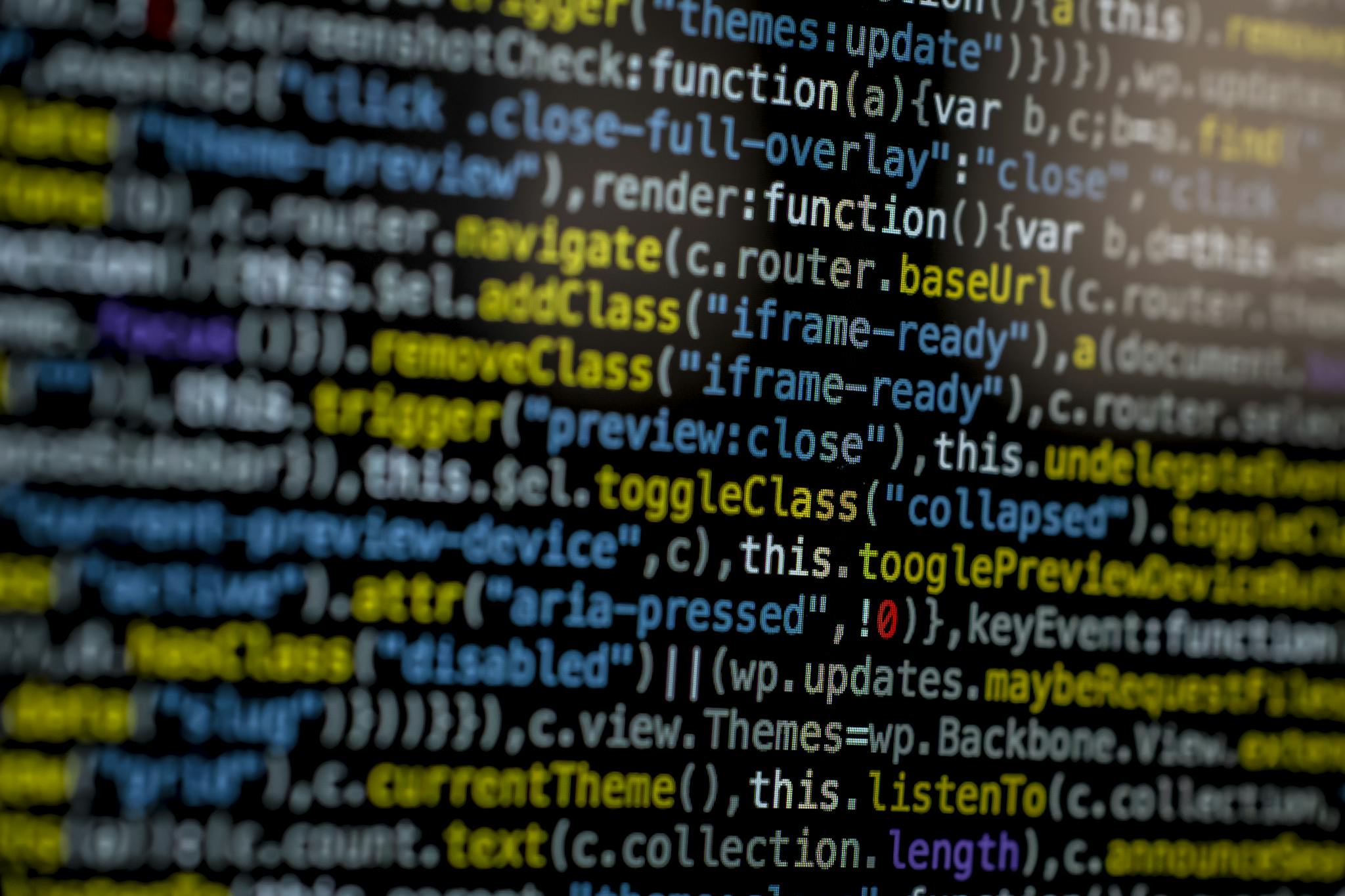 An extreme close-up of colorful programming code on a computer screen, showcasing development and software debugging.